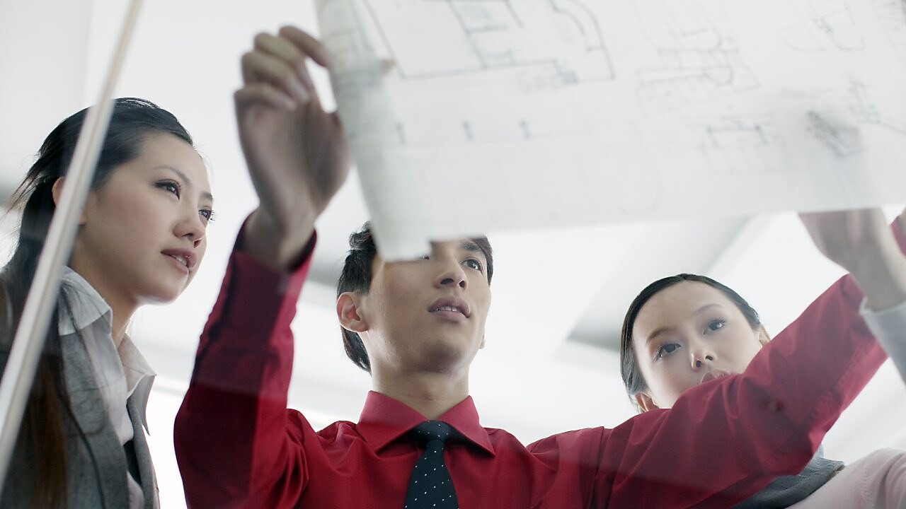 man showing bluprint to colleagues