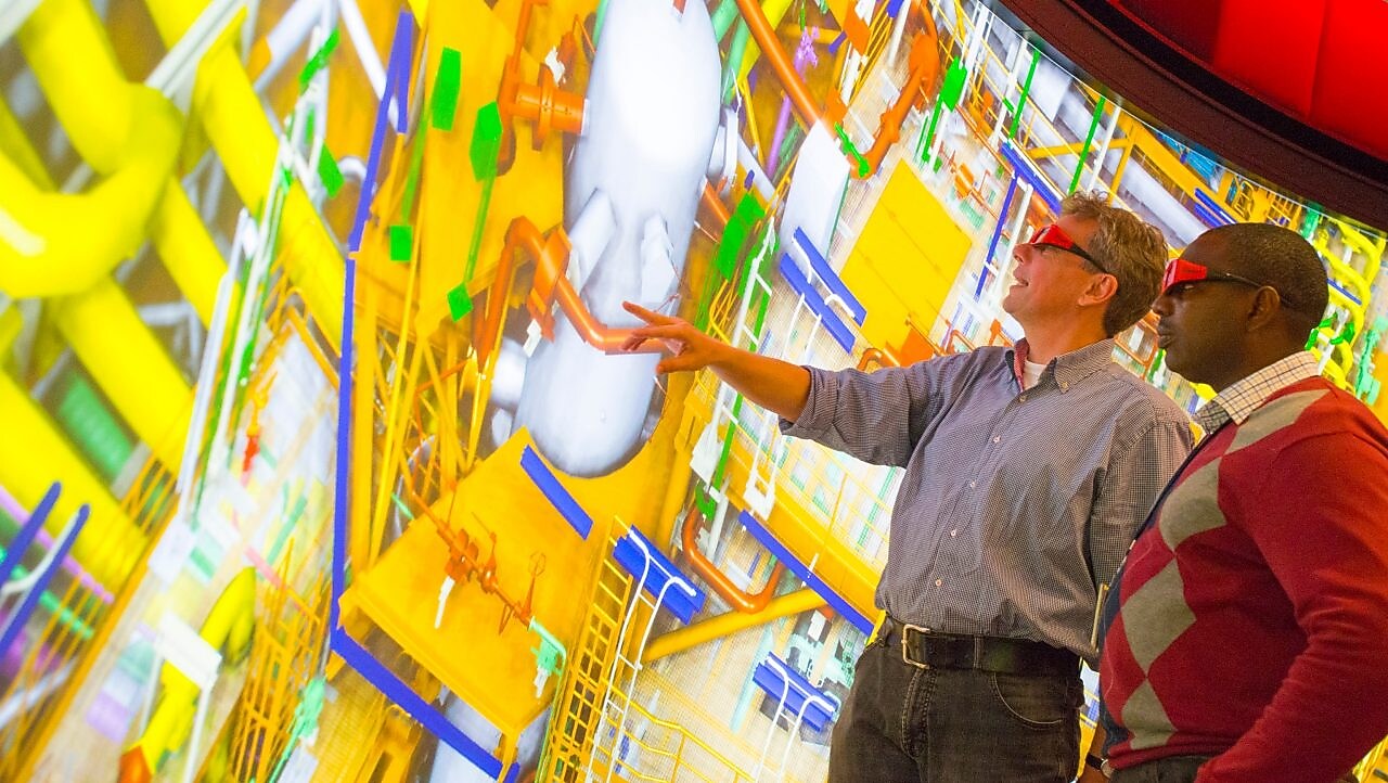 deux hommes regardant un grand écran avec des lunettes 3D