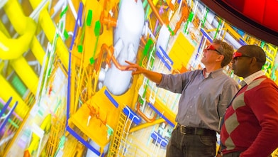 deux hommes regardant un grand écran avec des lunettes 3D