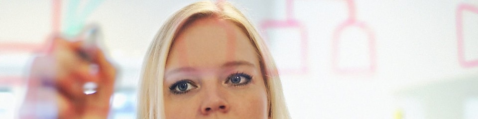 Suède, une femme d’affaires écrit sur une paroi en verre dans son bureau