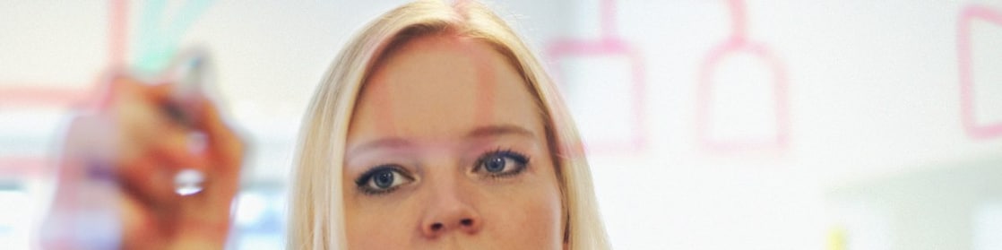 Suède, une femme d’affaires écrit sur une paroi en verre dans son bureau