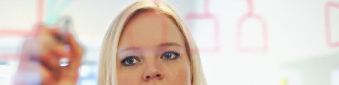 Suède, une femme d’affaires écrit sur une paroi en verre dans son bureau