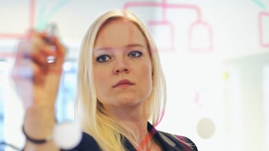 Suède, une femme d’affaires écrit sur une paroi en verre dans son bureau