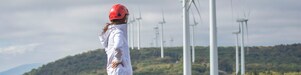 Une employée de Shell devant une éolienne.