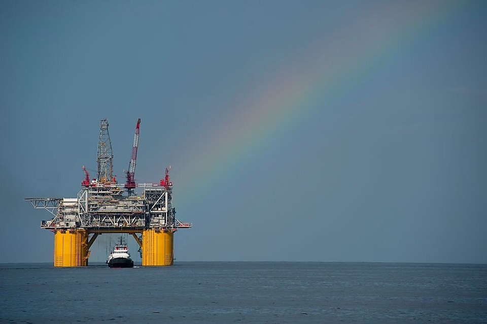 Plateforme offshore de Shell avec un arc-en-ciel en arrière-plan.
