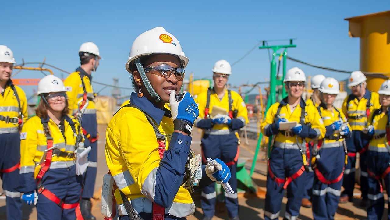 Une femme ingénieur Shell à la tête de son équipe sur un site d’exploitation.
