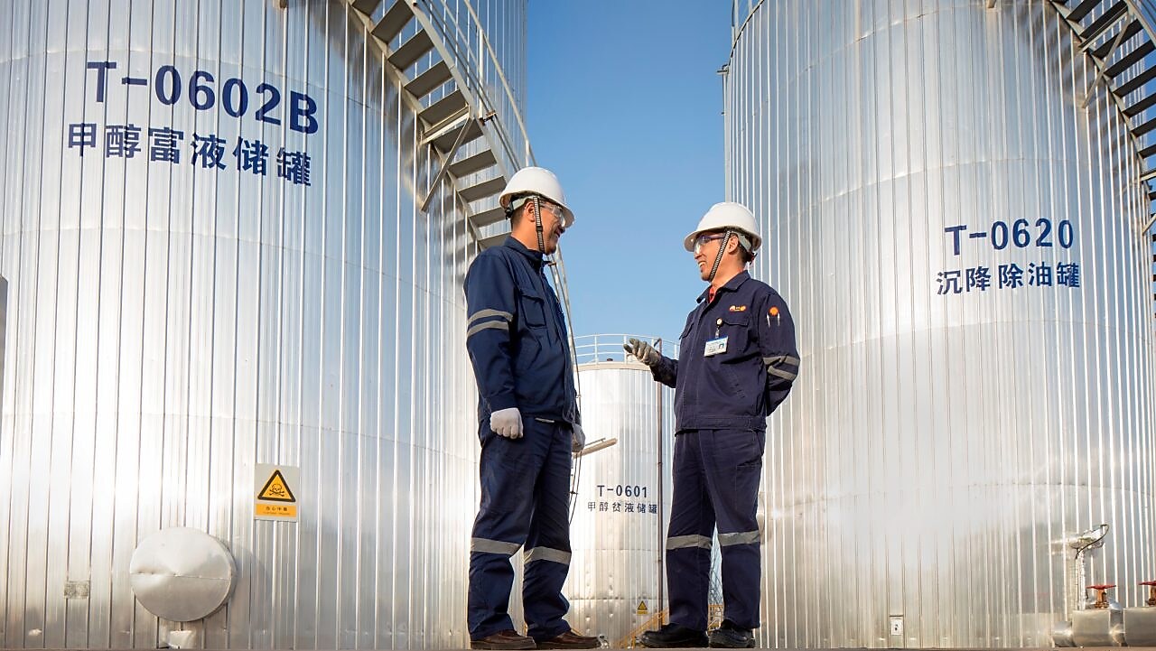 Deux ingénieurs asiatiques de Shell se rencontrent sur un site d’exploitation.