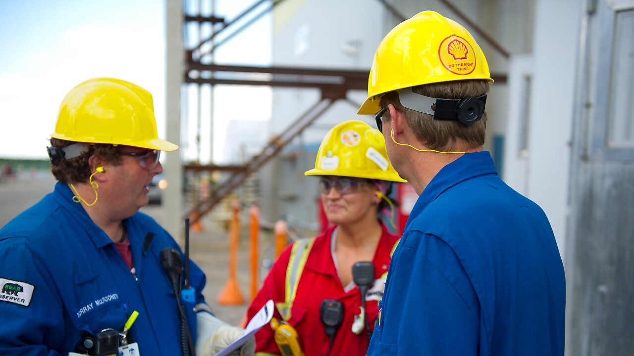 Employés Shell discutant sur le terrain