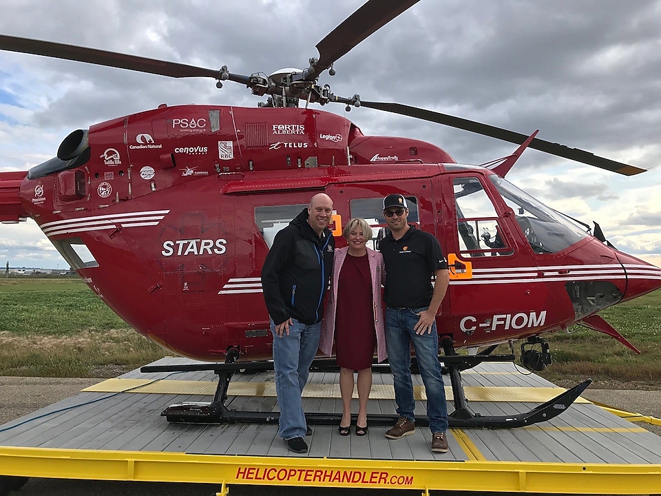 Les employés de Shell Cory Hagen, superviseur à Gold Creek, et Dustin Listhaeghe, chef opérateur, prennent la pose avec les membres de l’équipage de STARS sur la base albertaine de STARS à Grande Prairie.