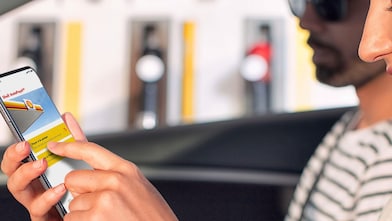 Femme dans un véhicule stationné qui utilise Shell AutoPayémc