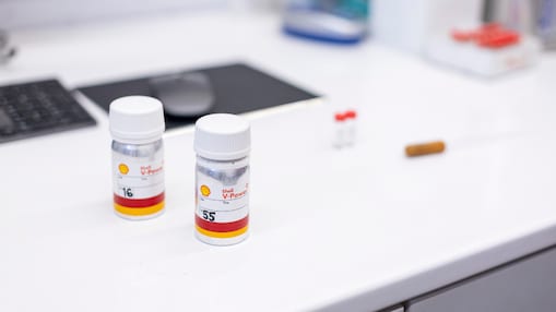 hand holding a sample tube of v power on a lab