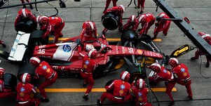 A close up of Ferrari car in the garage with Charles getting out of it