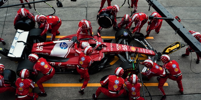 A close up of Ferrari car in the garage with Charles getting out of it