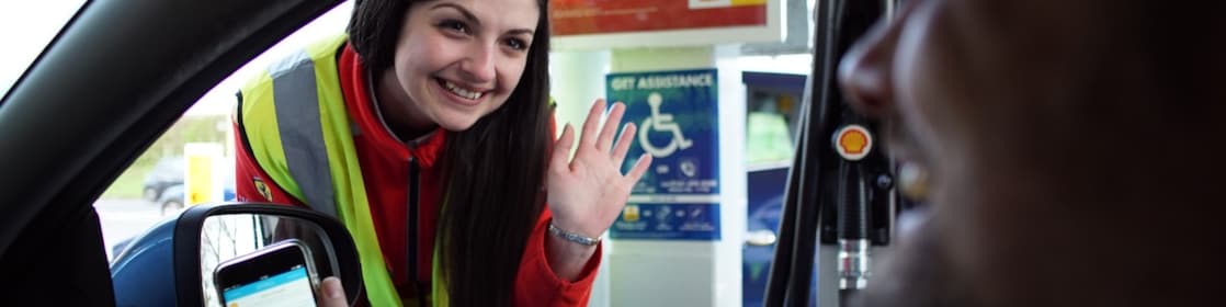 A woman at shell station helps a disabled man to refuel his car