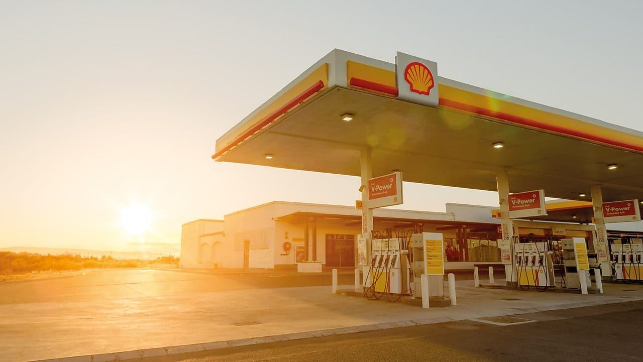 Soleil se levant derrière une station d'essence Shell