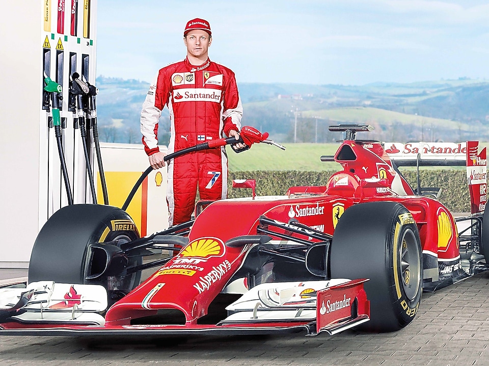 Pilote Ferrari F1 versant de l&rsquo;huile Shell Helix Ultra dans le moteur d'une voiture
