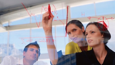 Femme d'affaires traçant un graphique sur une vitre